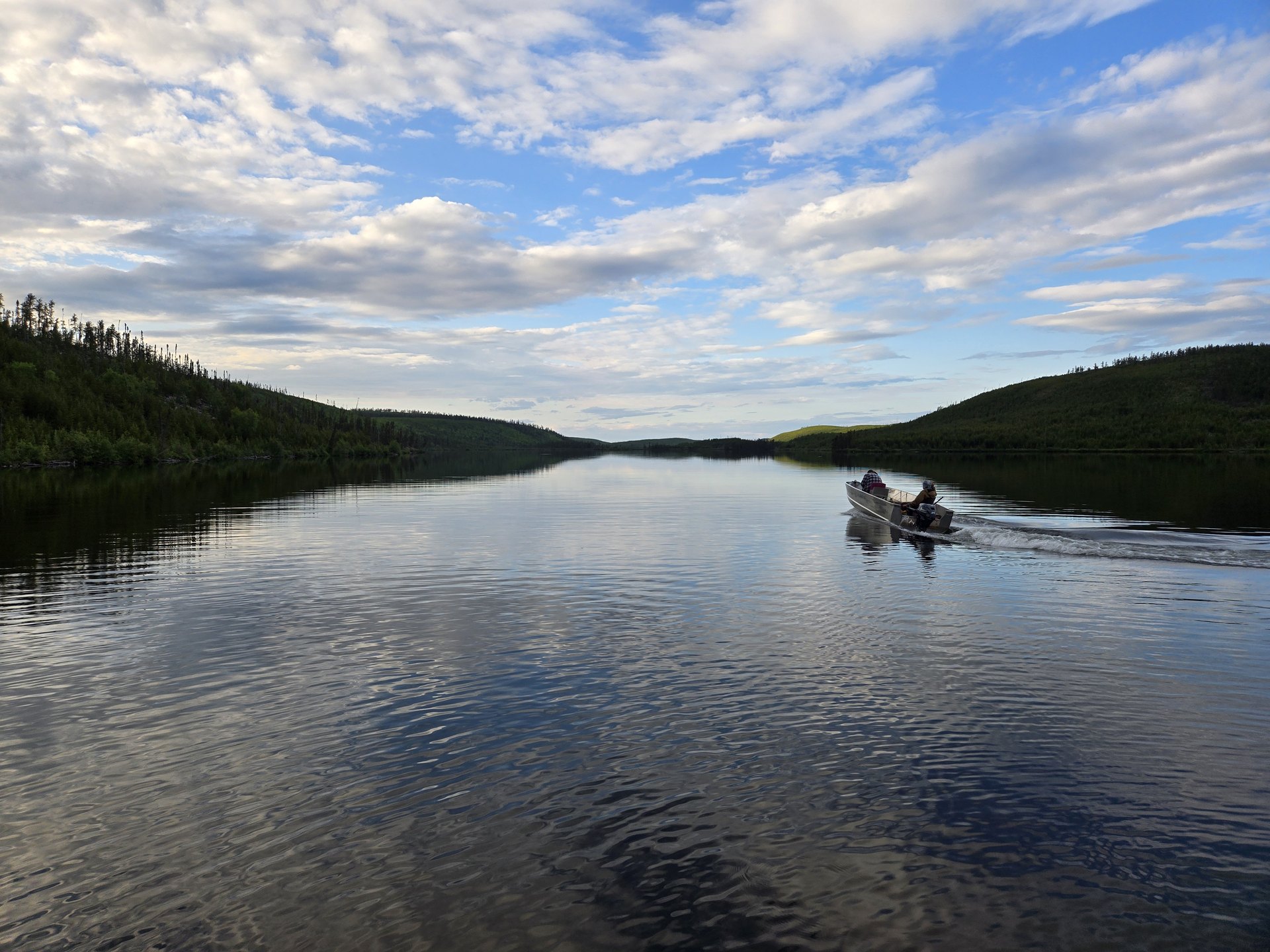 A boat running on Russell Lake under an evening sky in northern Saskatchewan